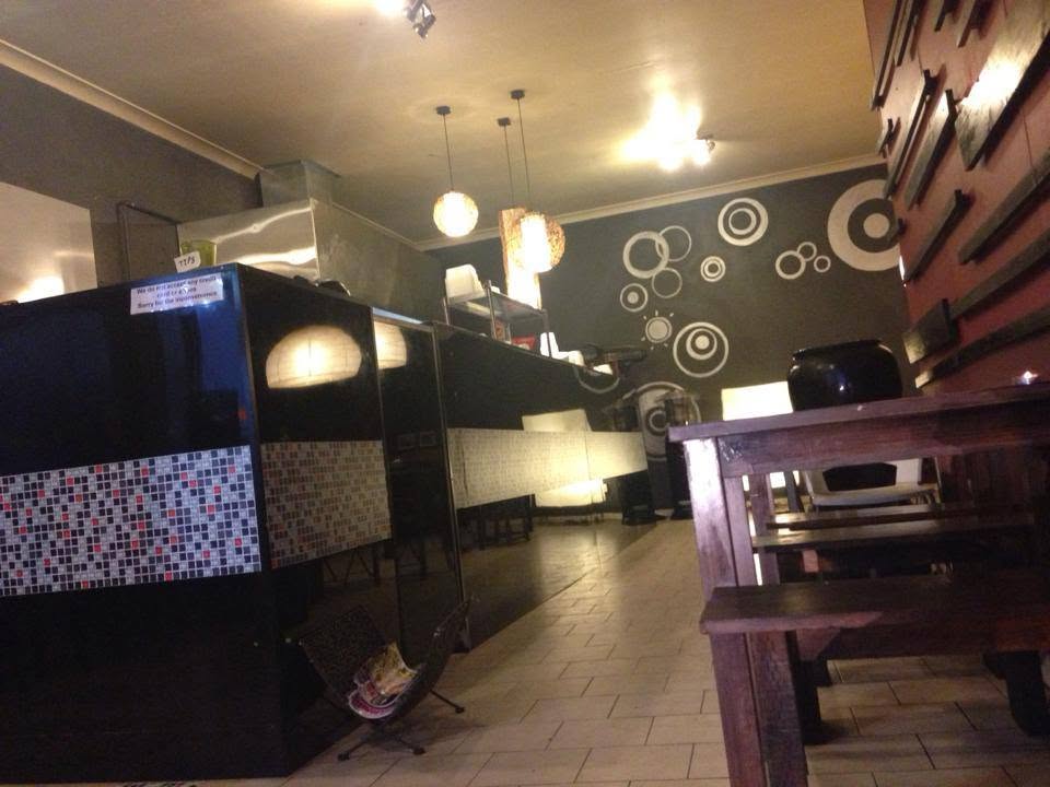 Inside Bangkok Balcony, showing the service counter, pendant lights and timber bench seating
